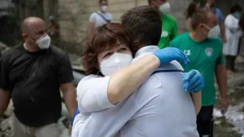 Getty Images Healthcare workers embrace after the attack in Kyiv