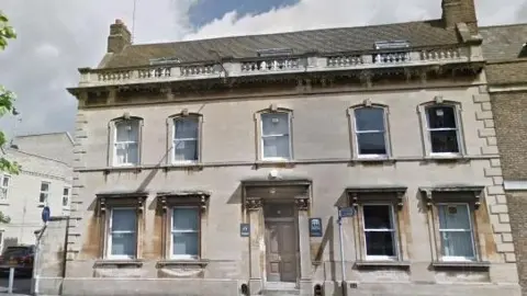 Historic beige-coloured building with rectangle windows.